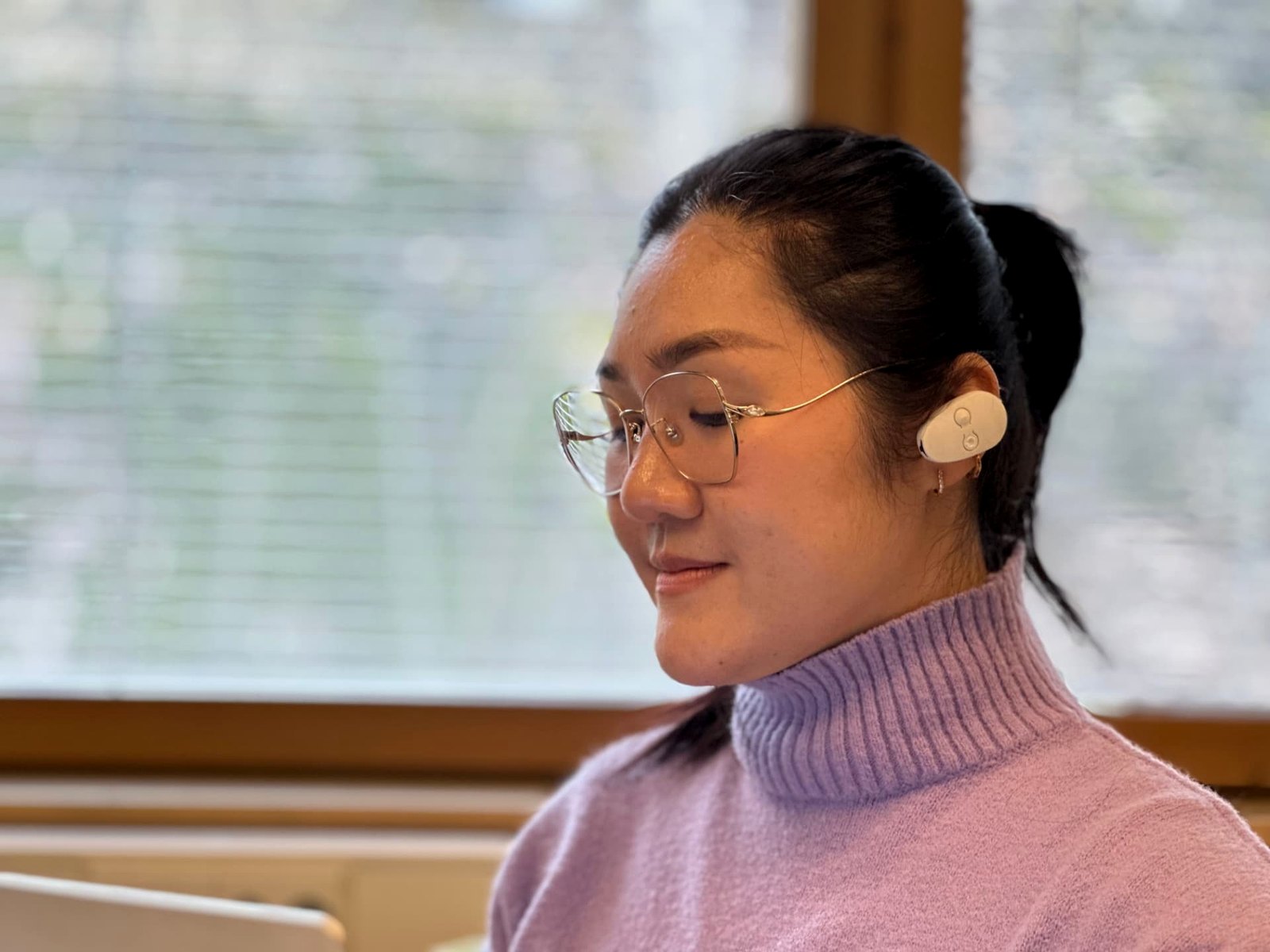 EVANES clipped to the upper ear of a woman